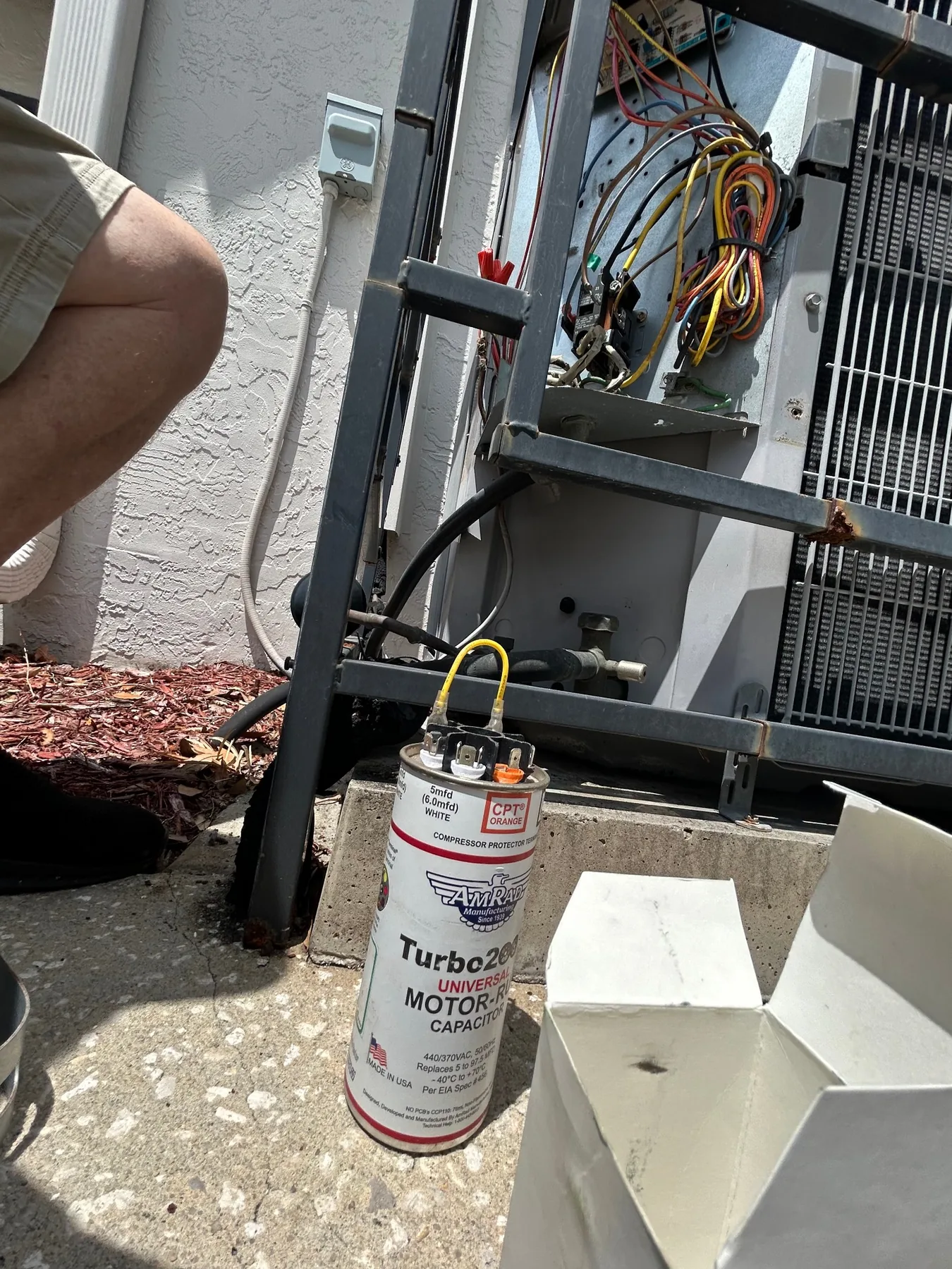 Outdoor condenser electrical repair with capacitor visible